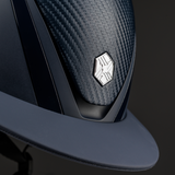Charles Owen Hyda Carbon riding hat in Navy Matte/Navy Gloss, close-up of the crown and peak on a dark background